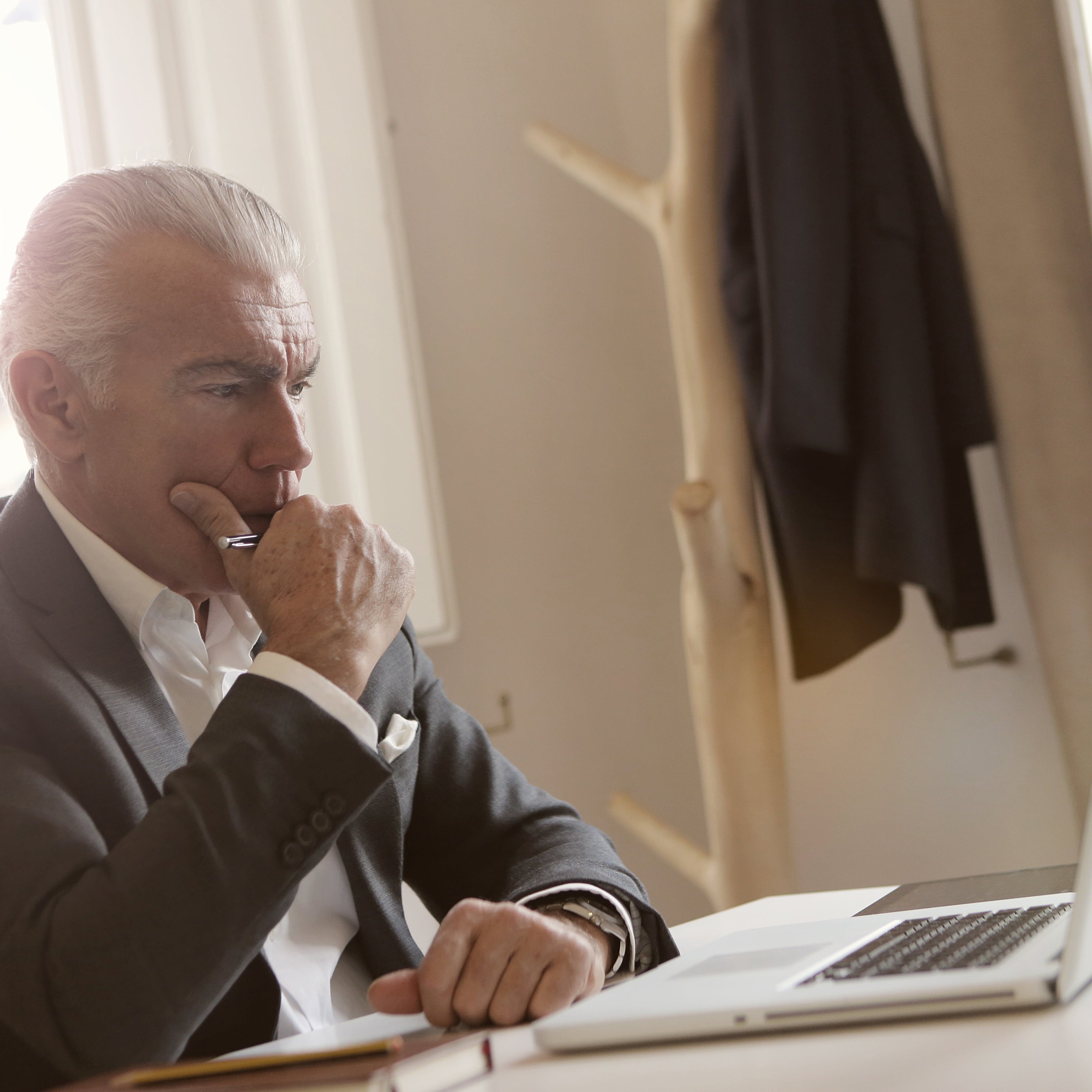 A man thinking and staring at his computer.
