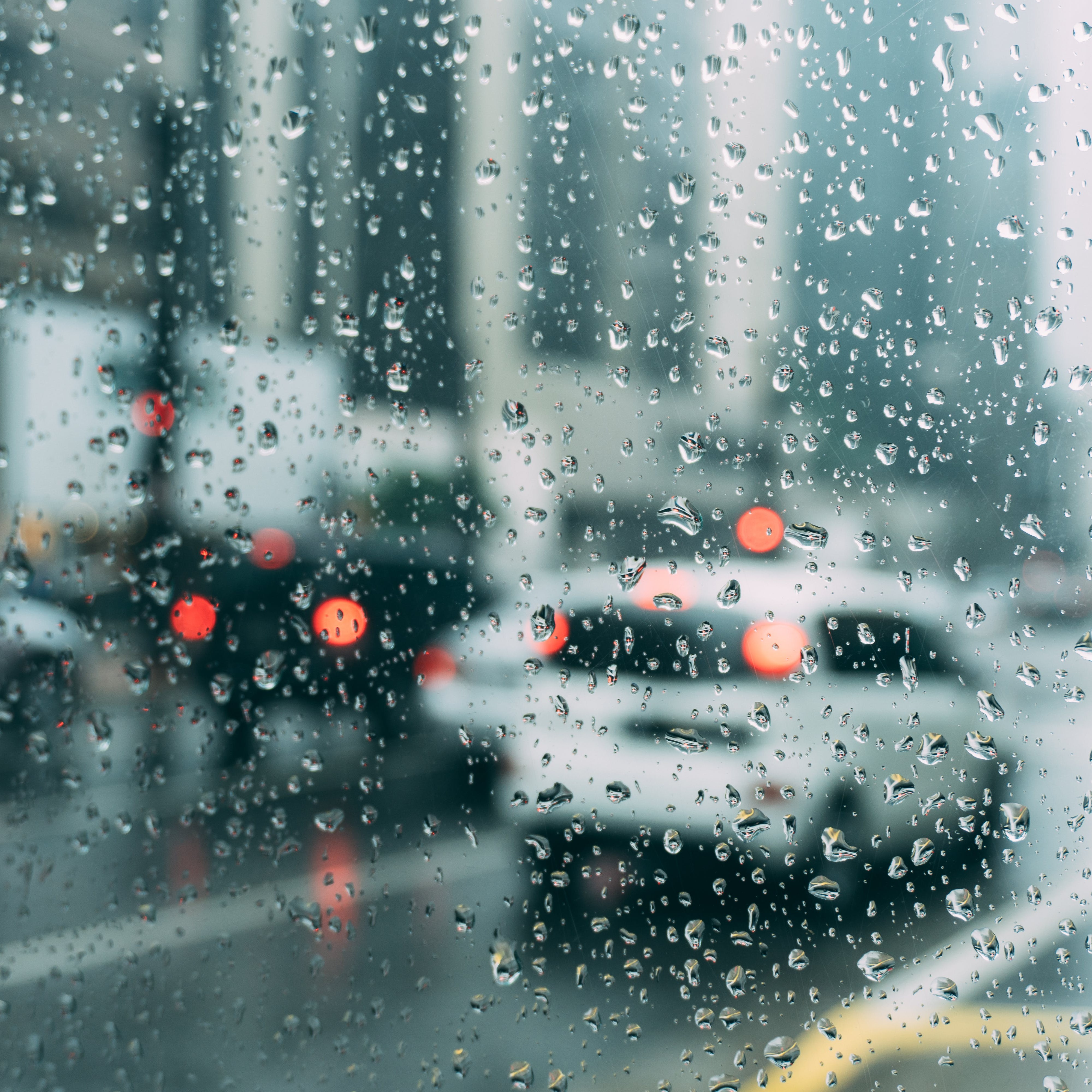 A rainy window with cars outside.